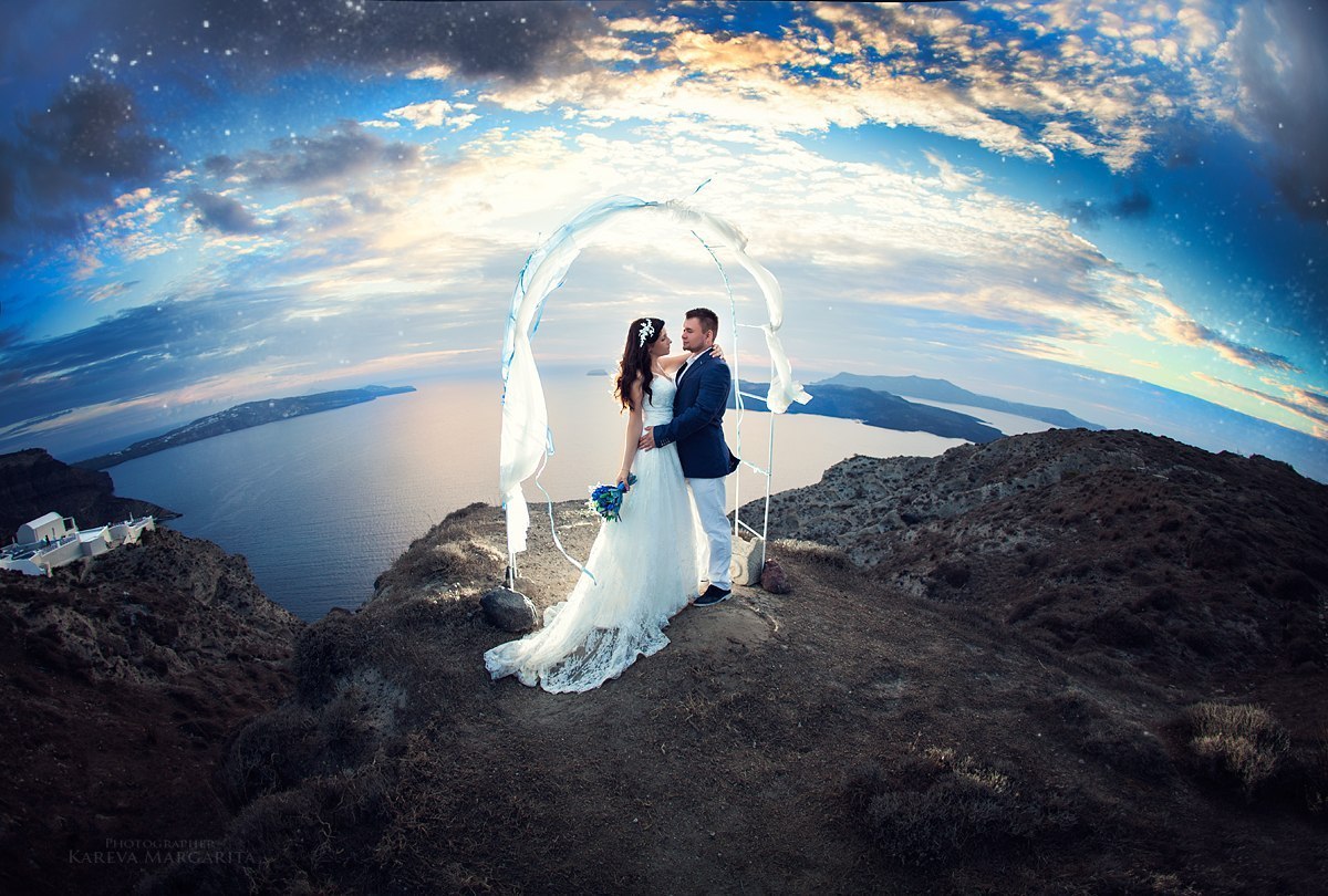 Фото Жених с невестой стоят на горе на фоне воды, фотограф Маргарита Карева