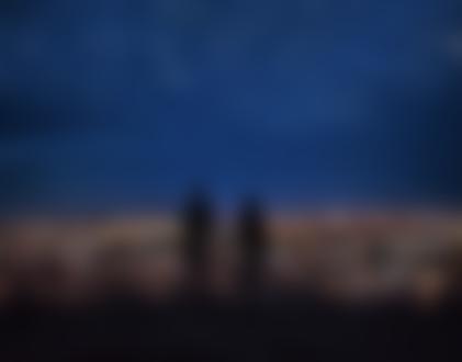 Фото Обнаженные мужчина и девушка держатся за руки, смотря на город и звездное ночное небо, фотограф Joel Sossa