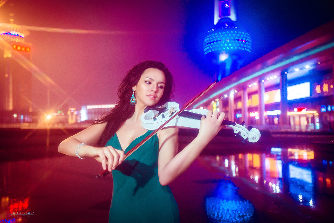 Фото Скрипачка и певица Ivet Curbelo, играющая на скрипке на ночной улице города, фотограф Lola Pidluskaya