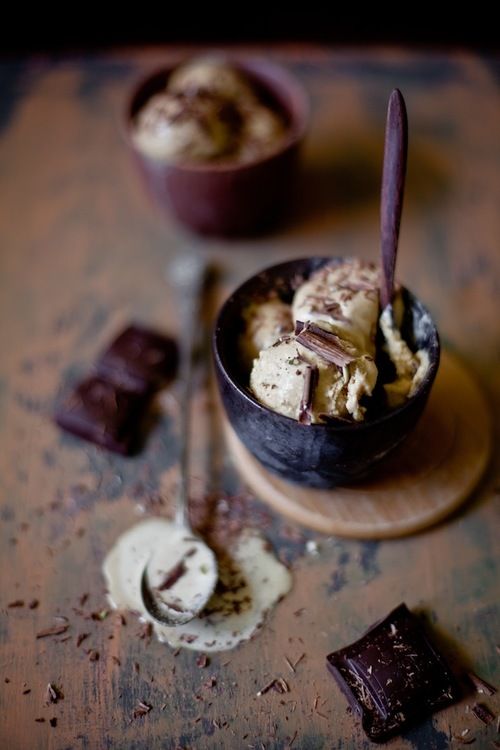 Фото Тарелка с ванильным мороженным, посыпанным шоколадом, и кусочки шоколада на столе