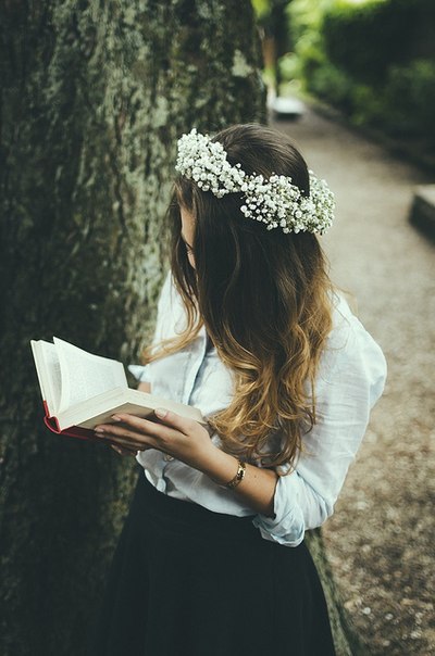 Фото Девушка с белым венком на голове читает книгу
