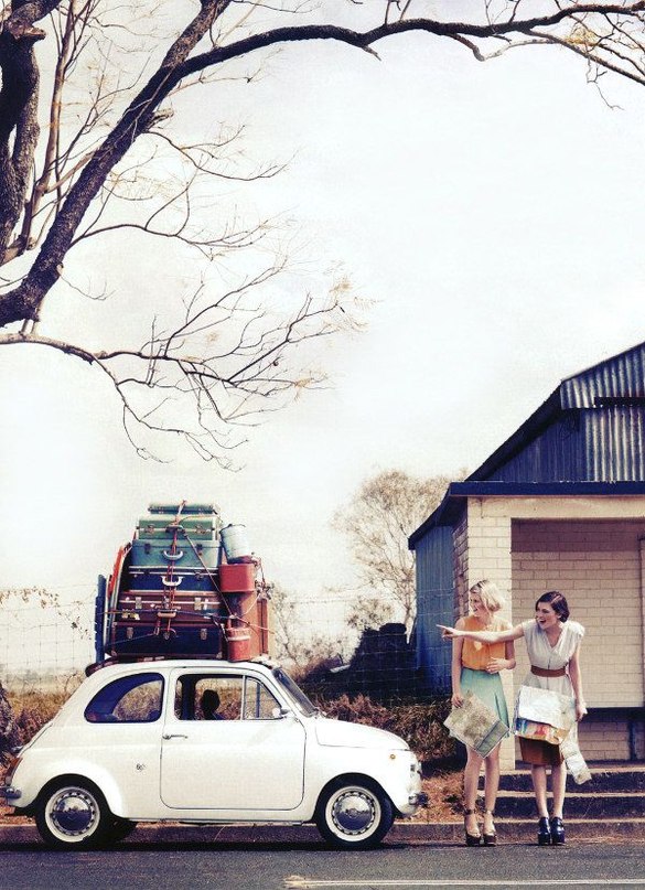 Фото Машина на которой лежат чемоданы и две девушки возле дома