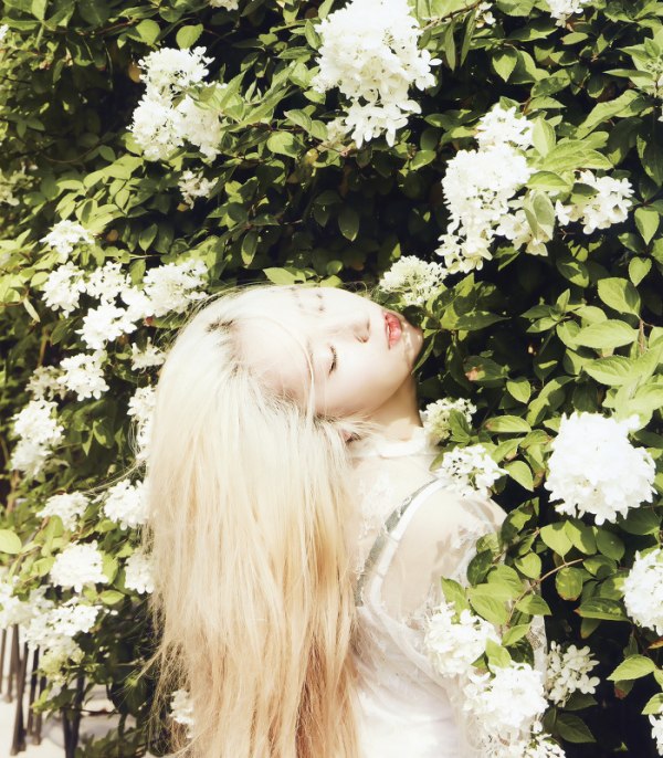Фото Кристал / Krystal из южно-корейской группы F (x) стоит закрыв глаза у цветущего дерева