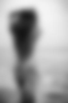 Фото Девушка в мокрой накидке стоит на берегу