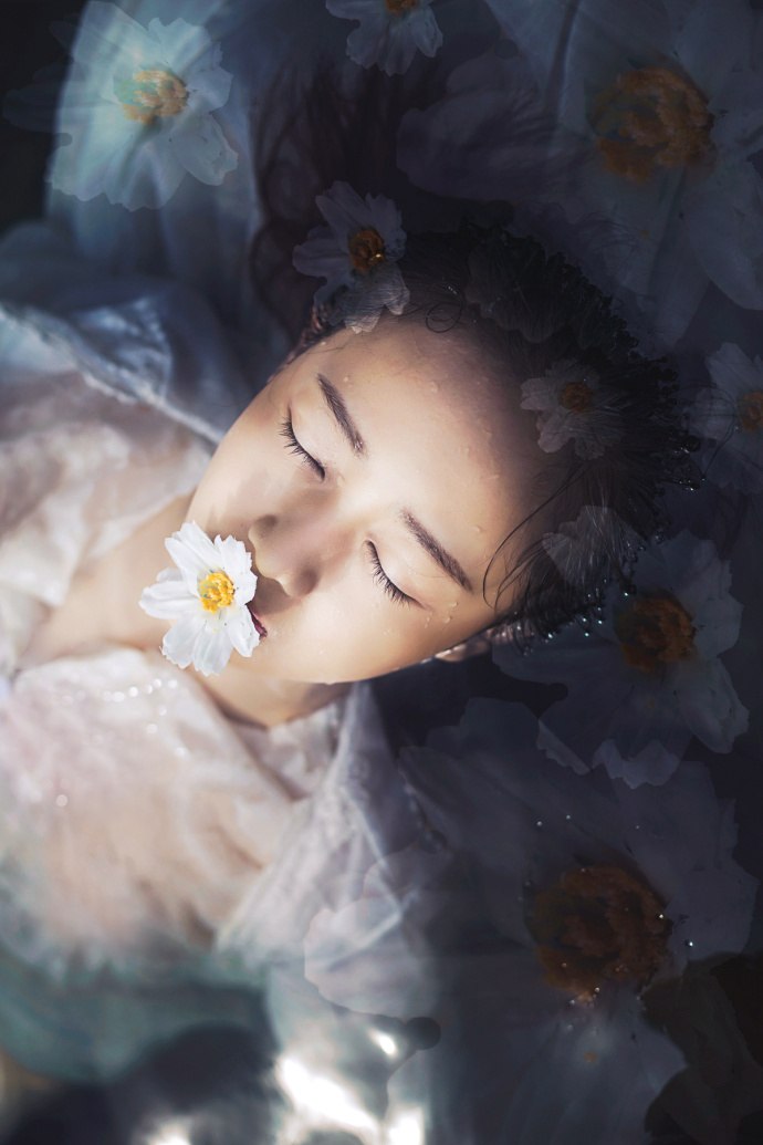 Фото Девушка. тело которой под водой, держит во рту цветок