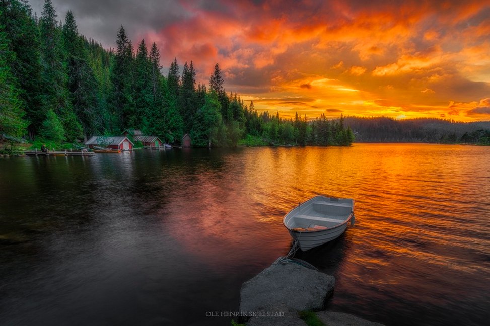 Фото Лодка в воде на фоне домииков в окружении елового леса и на фоне заката, by Ole Henrik Skjelstad