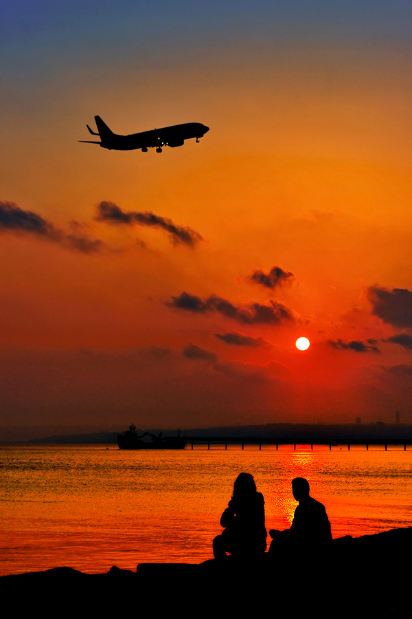 Фото Парень с девушкой наблюдают за закатом и в небе пролетает самолет