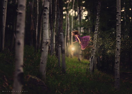 Фото Девочка с фонариком в руке прыгает по деревьям, фотохудожник Lisa Holloway