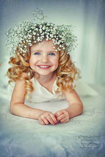 Фото Маленькая девочка с белыми цветами в волосах улыбается, фотограф Наталья Законова