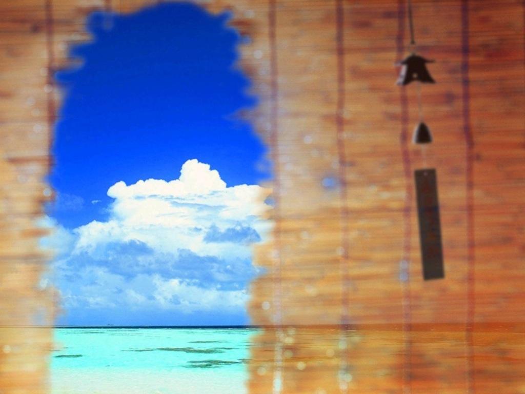 Фото Облака на небе и море видны в дыре бамбуковых ролетов