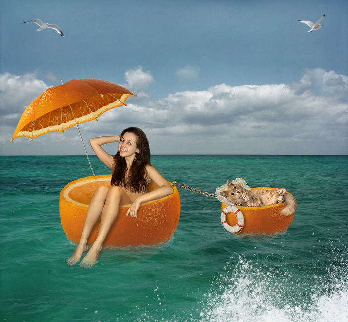 Фото Девушка под зонтиком из апельсина и кот плывут по морю в лодочках из апельсина
