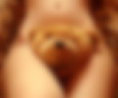 Фото У девушки между ног лежит игрушечный медведь