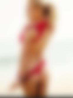 Фото Pamela Anderson / Паиела Андерсон, актриса и фотомодель в красном купальнике стоит у моря