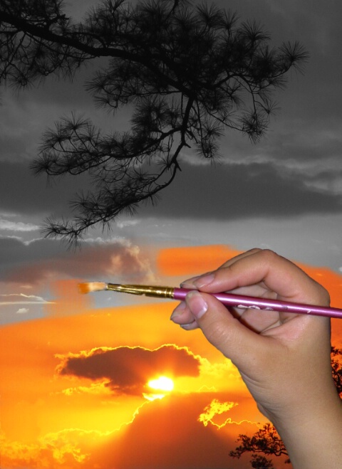 Фото Рука с кистью рисует закат Солнца