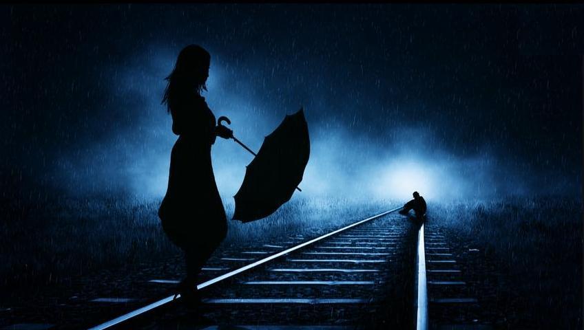 Фото Девушка с зонтом стоит на железнодорожной дороге и смотрит на сидящего поодаль парня