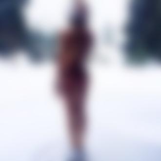 Фото Девушка в шлеме, купальнике и кроссовках стоит на снегу