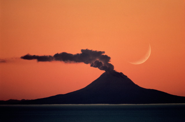 Фото Полумесяц на небе над дымящимся вулканом
