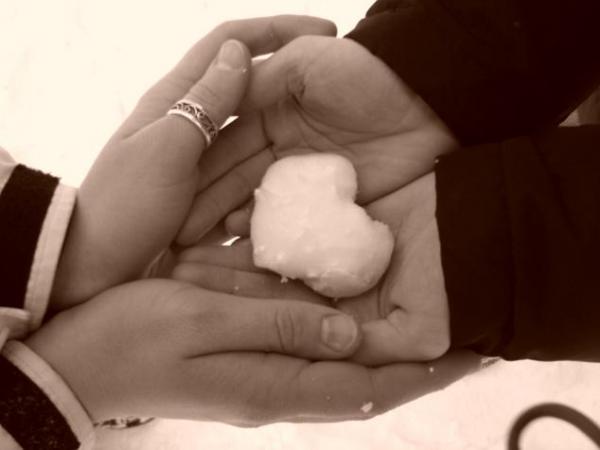 Фото Руки мужчины и девушки держат снежное сердце