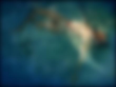 Фото Полуобнаженная девушка с мечтательной улыбкой и закрытыми глазами плавает в воде вместе с черепахой