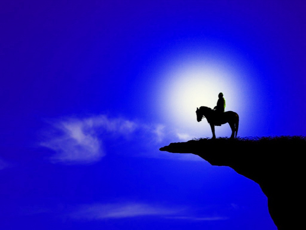 Фото Темный силуэт всадника на лошади, стоящей на краю каменного утеса и смотрящего на ночное небо с яркой Луной