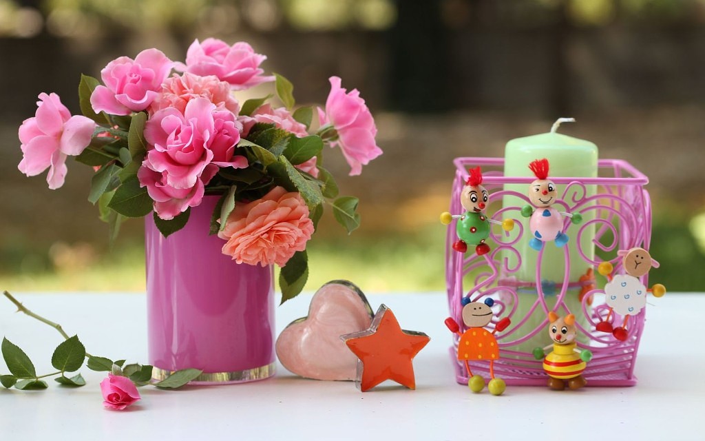 Фото Букет из роз и пионов и декоративная свеча на столе