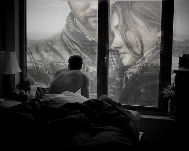 Фото Плюшевый мишка сиротливо сидит на подоконнике окна, в которое ранним утром смотрит парень сидя на постели, внизу просыпающийся город, в стекле отражение мужчины и женщины, разделенных черной рамой окна