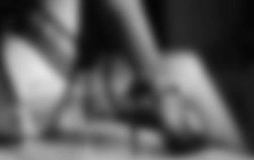 Фото Около ноги девушки в черных чулках и туфлях стоит бокал с вином