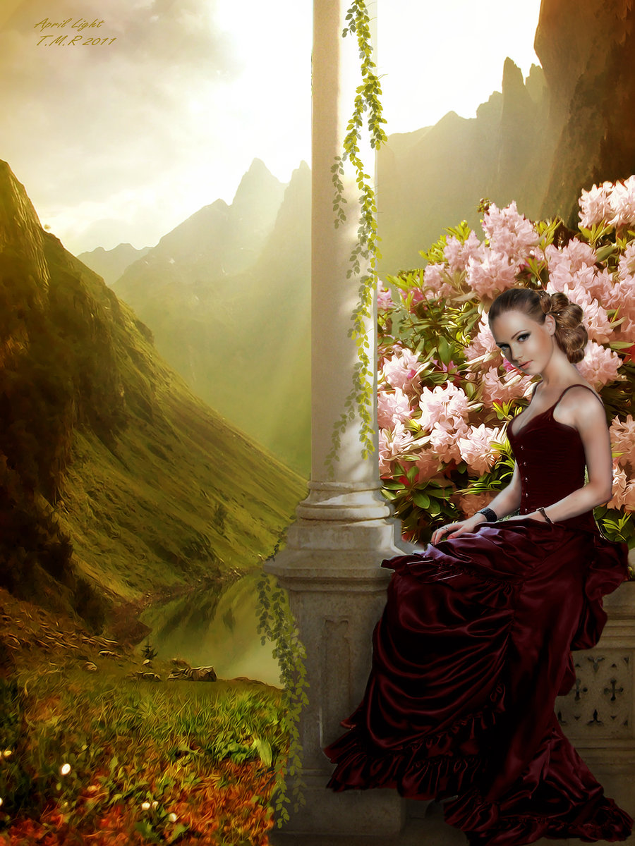 Фото Красивая девушка в длинном платье среди цветов на фоне гор и древнего  замка сидит на бордюрчике балкона