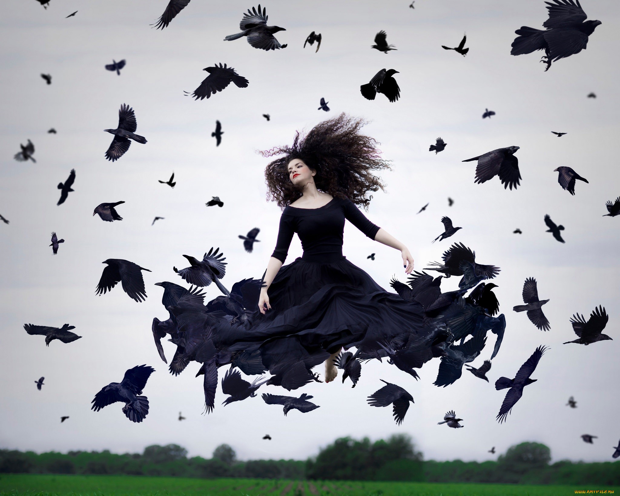 Фото Девушка в черном платье, парящая в воздухе