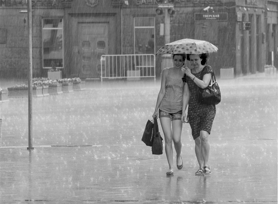 Фото Дочь и мама возвращаются домой с покупками, на пути их застал дождь