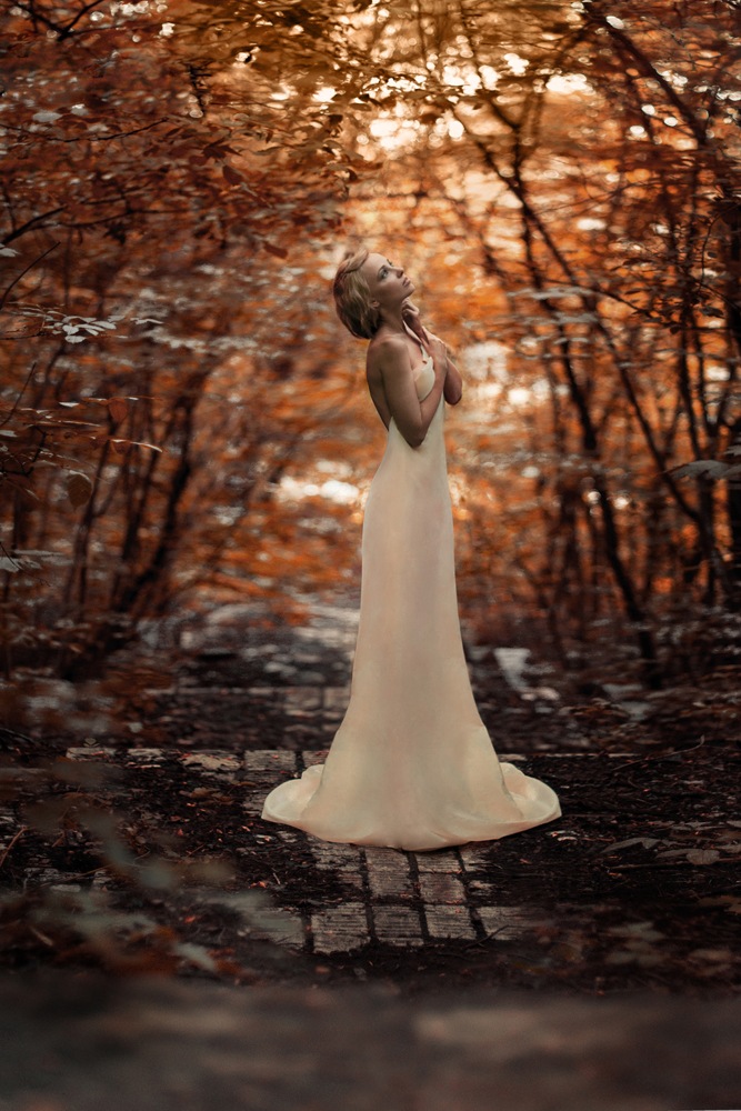 Фото Девушка в белом платье, сложив руки у груди, стоит среди деревьев с желтыми листьями и смотрит вверх, модель Анна, визаж Таня Яременко, фотограф Bogdan Popravko