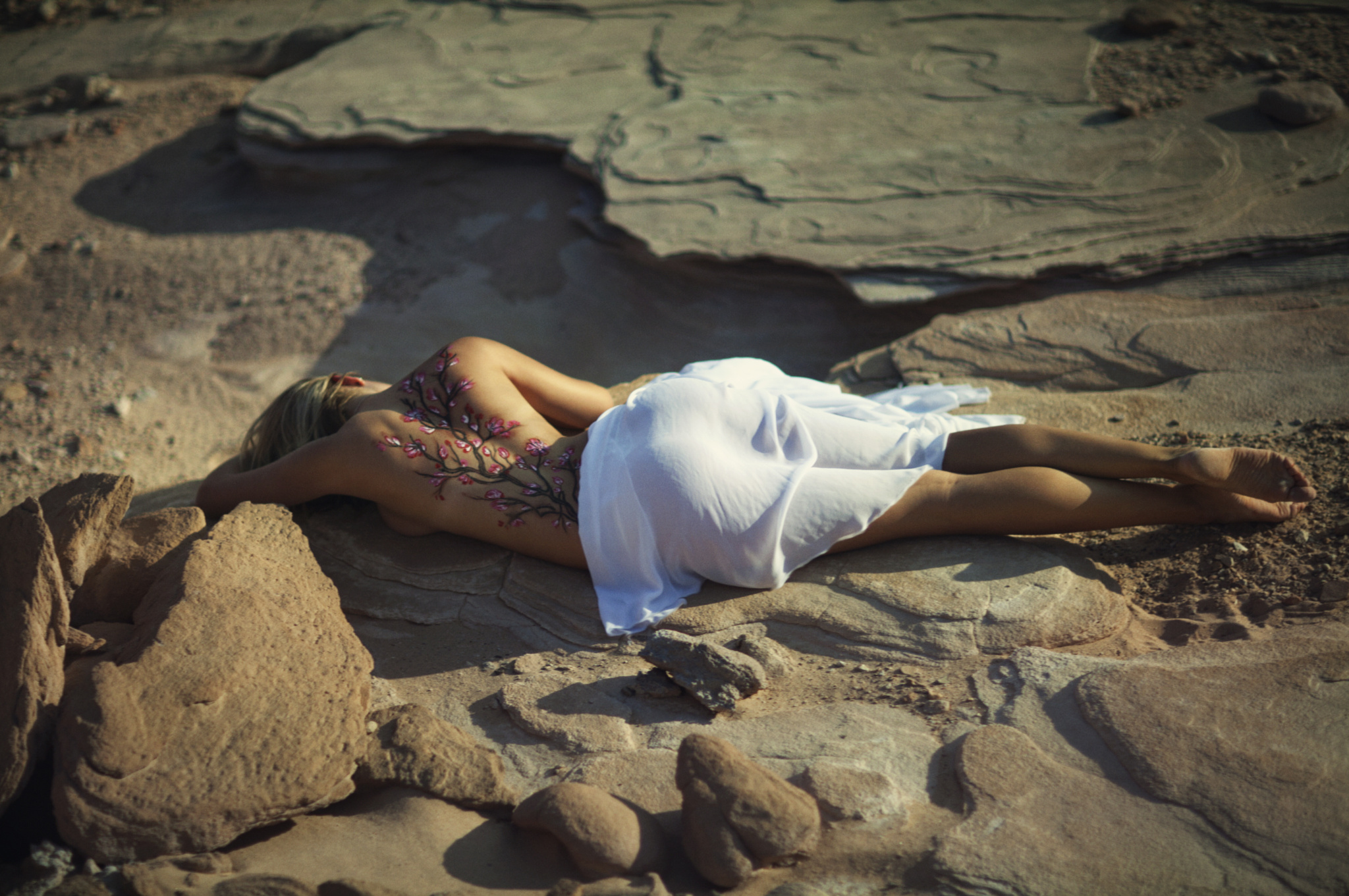 Девочка лежит на песке