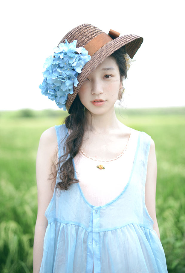 Фото Девушка - азиатка в шляпе с цветами
