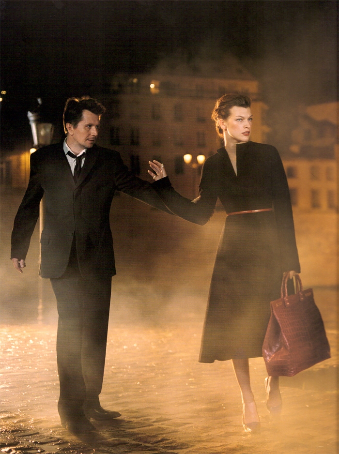 Фото Актриса Милла Йовович Milla Jovovich и актер Гари Олдман / Gary Oldman стоят на ночной улице укутанной туманом