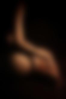 Фото Тело сидящей в темноте обнаженной девушки