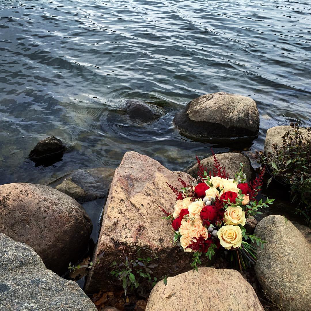 Фото На камне у морской воды лежит букет из красных и желтых роз, фотограф Юрий Лукша
