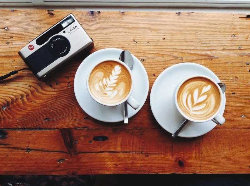 Фото Фотоаппарат и две чашечки кофе стоят на деревянной доске, автор Polek Kholodova