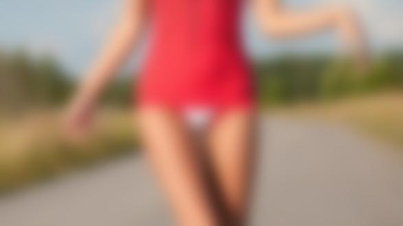Фото Стройная девушка эротичной походкой идет по дороге