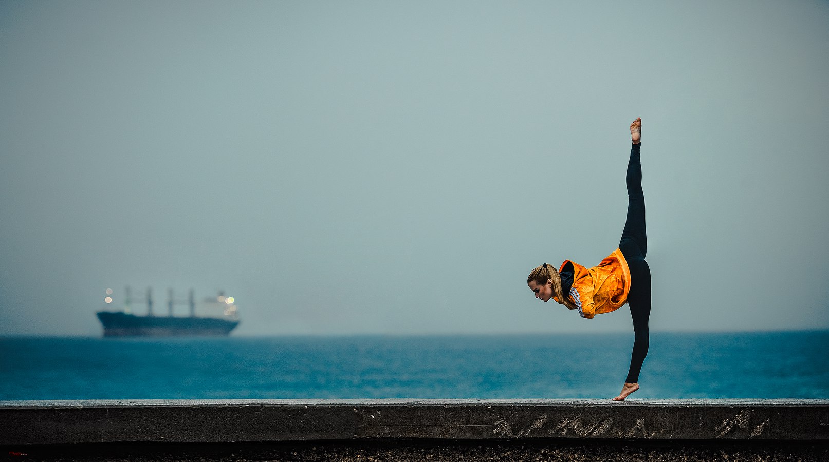 Фото Девушка в гимнастической позе стоит на фоне корабля в море, фотограф Баженов Денис