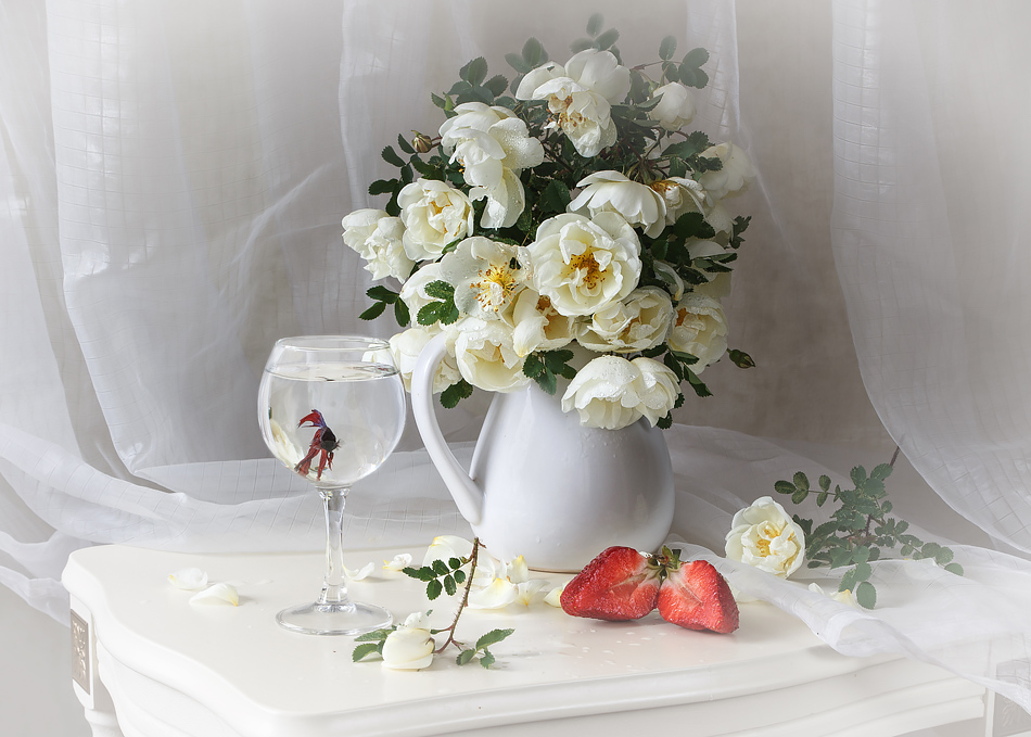 Фото Белые розы в кувшине, на столе лежит клубника, роха и стоит бокал с водой, где плавает рыбка, by Daykiney