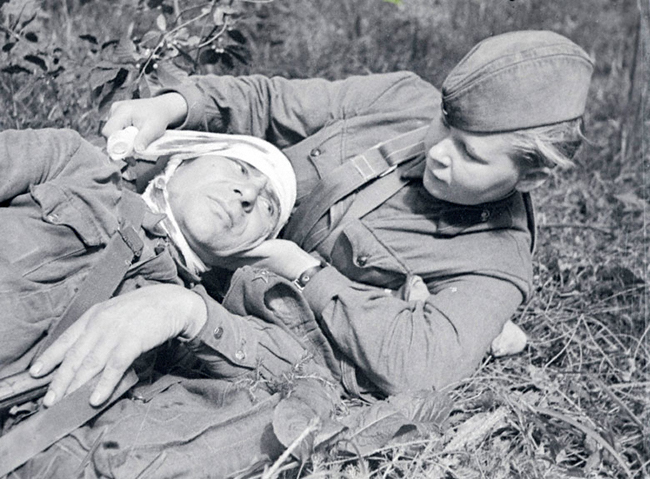 Фото Сандружинница Скотинкина С. Г перевязывает раненого бойца, Северо-Западный фронт 1942 год