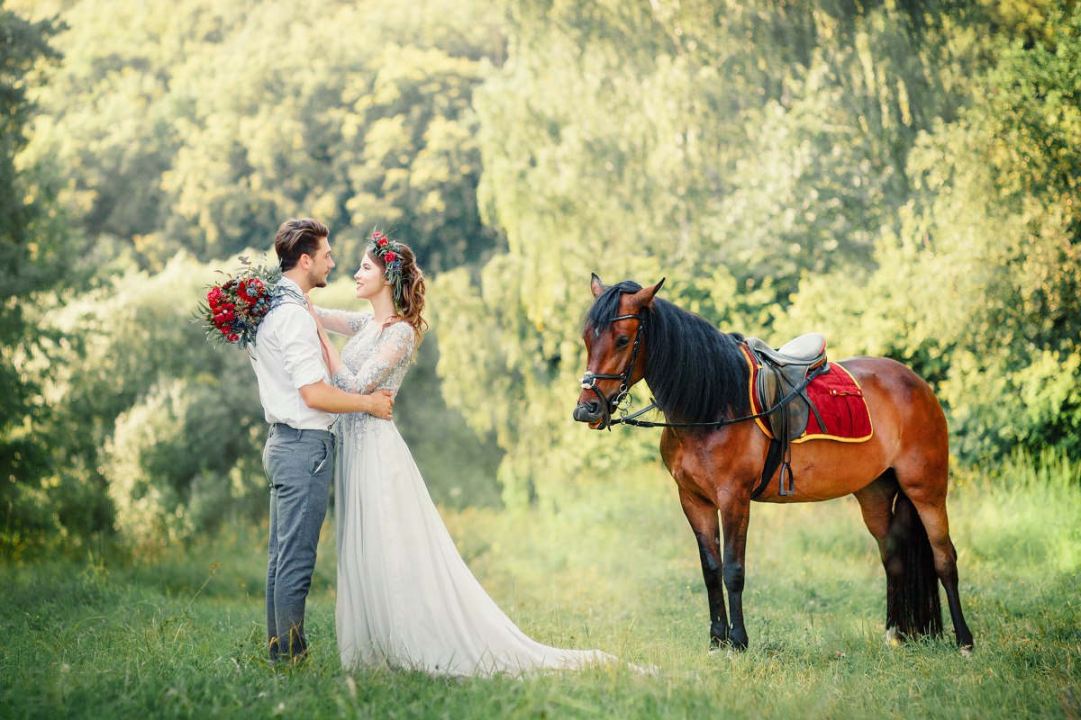Фото Мужчина с девушкой обнимаются, рядом стоит коричневая лошадь, фотограф Павел Михайлов