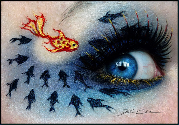 Фото Девушка с темным макияжем, тенями нарисованы рыбы вокруг глаза: одна золотая и множество маленьких черных рыбешек