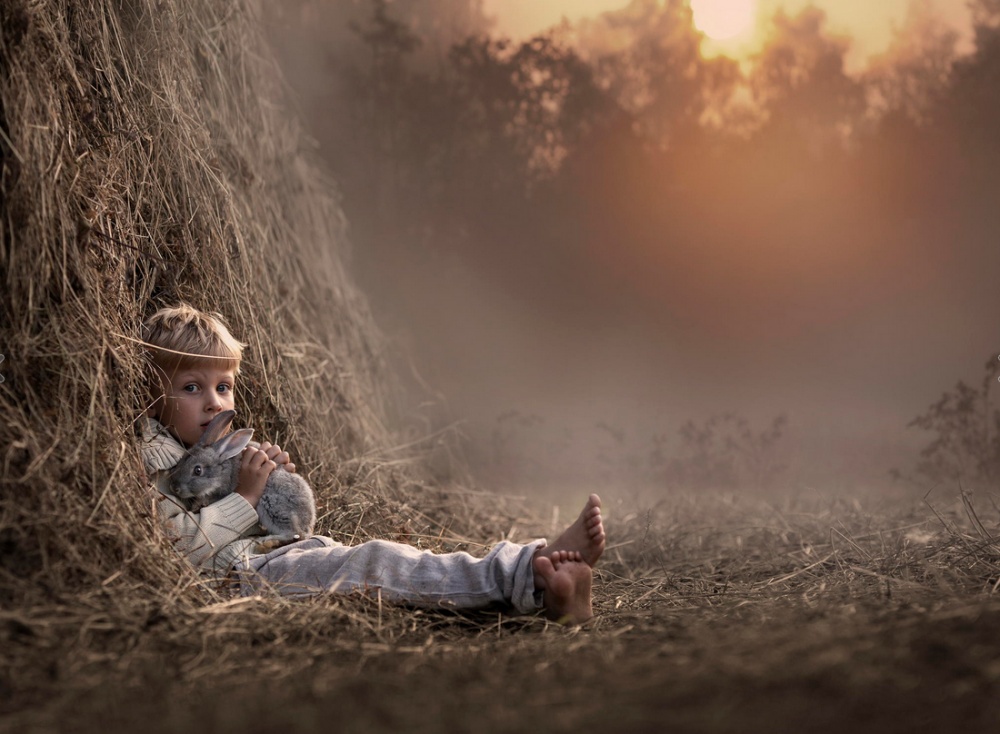 Фото Мальчик с кроликом сидит в стоге сена, фотограф Елена Шумилова