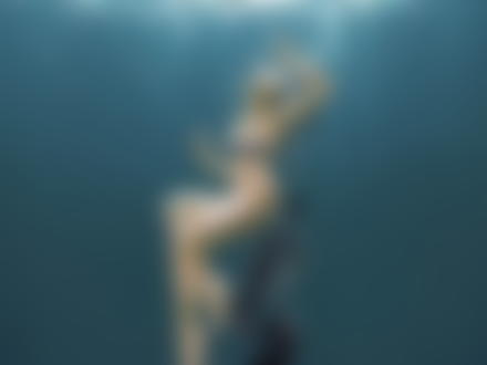 Фото Девушка с длинными темными волосами, полуобнаженная под водой