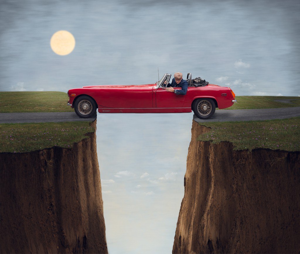 Фото Мужчина в красном автомобиле стоит над пропастью, by Logan Zillmer