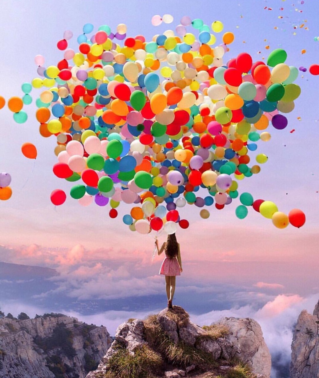Фото Девушка с разноцветными шарами стоит на холме