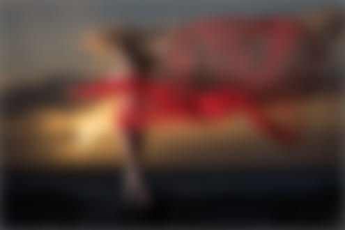 Фото Обнаженная девушка с красной развевающейся тканью стоит на фоне заката, фотограф Martin Zurmuehle