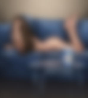 Фото Девушка в трусиках лежит на диване перед рядом стоящим столом