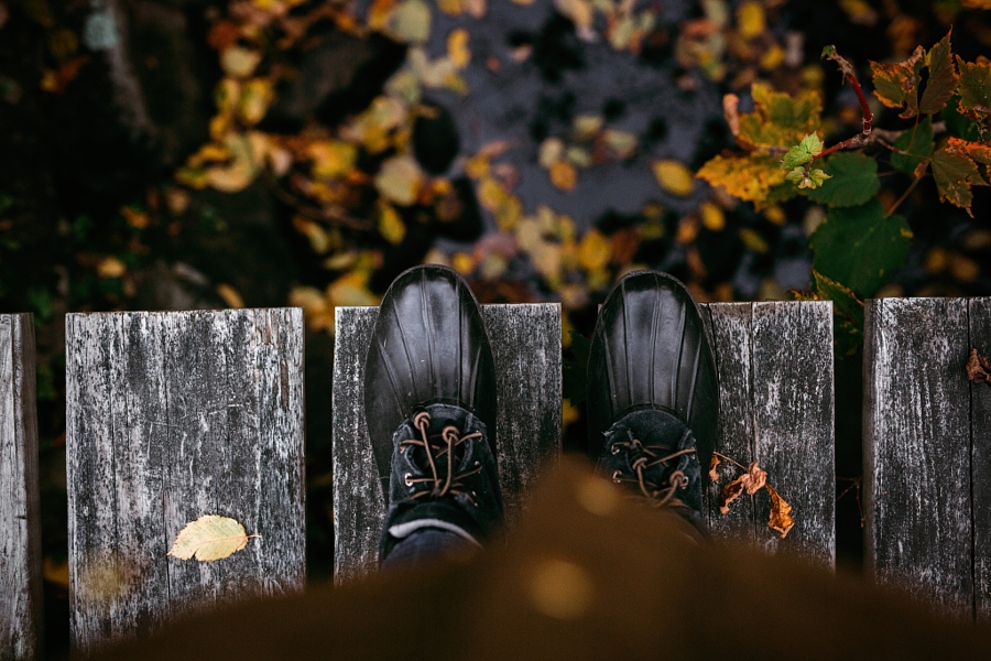 Фото Ноги в черной обуви на мостике над водой с осенними листьями, фотограф Gabriela Tulian